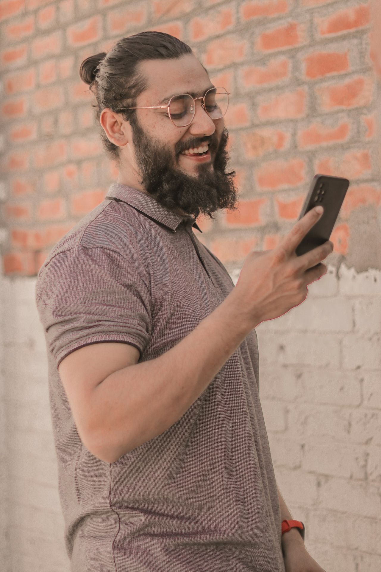 A man with a beard using a smartphone