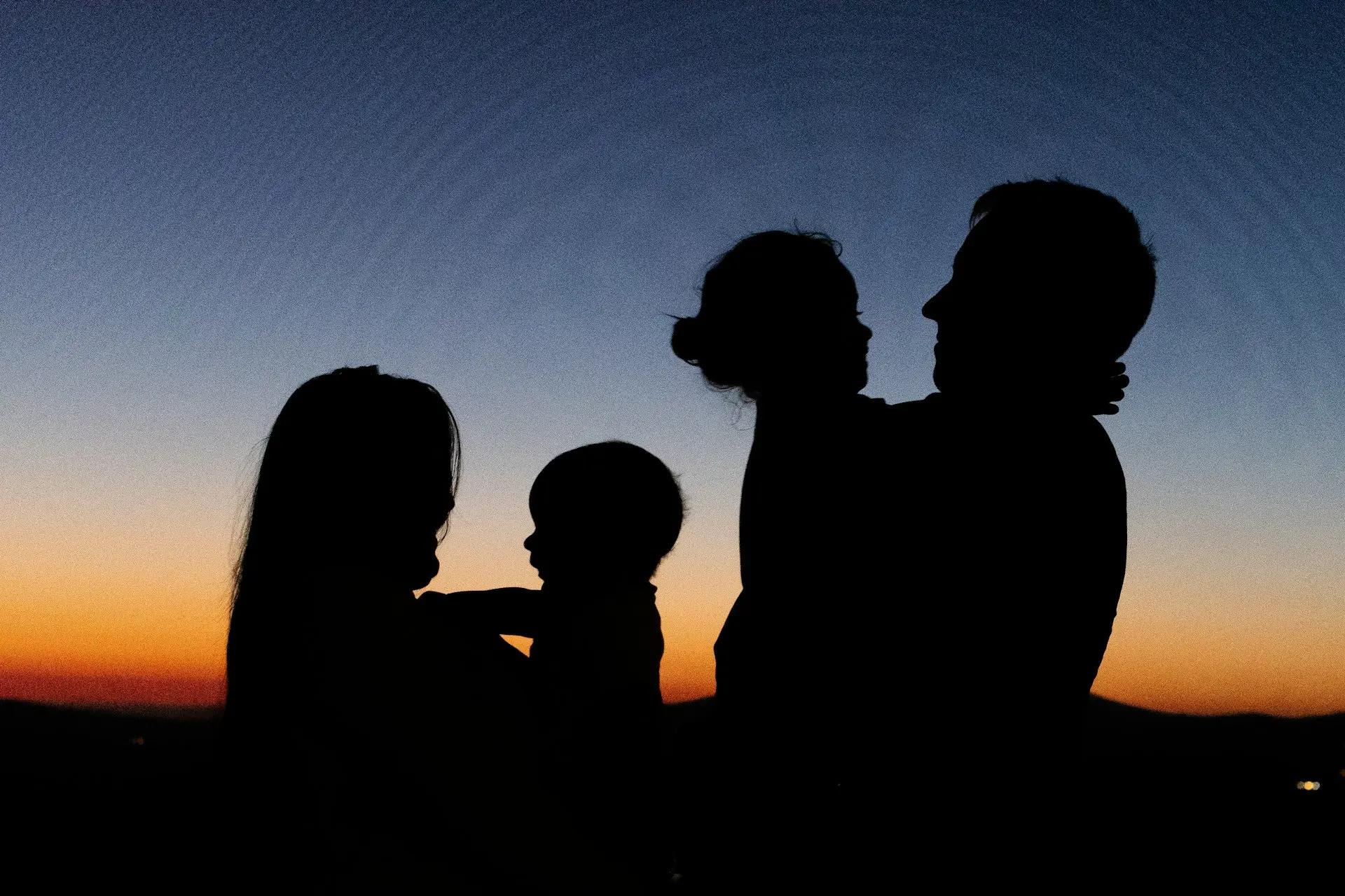 Silhouette of a mother, a father, and two children during sunset